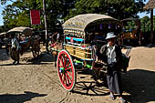 Inwa, Myanmar - tourists ride on a horse-drawn carriage. Riding on a horse cart is the easiest way to get around Inwa's narrow and dusty road to explore scatterred attractions. 